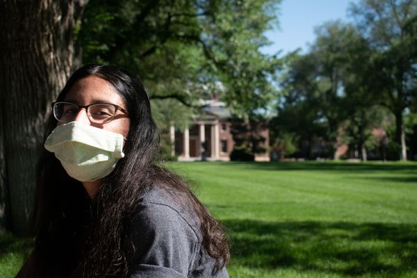 An incoming freshman at the University of Nevada, Reno, wears a mask in the campus's quad.