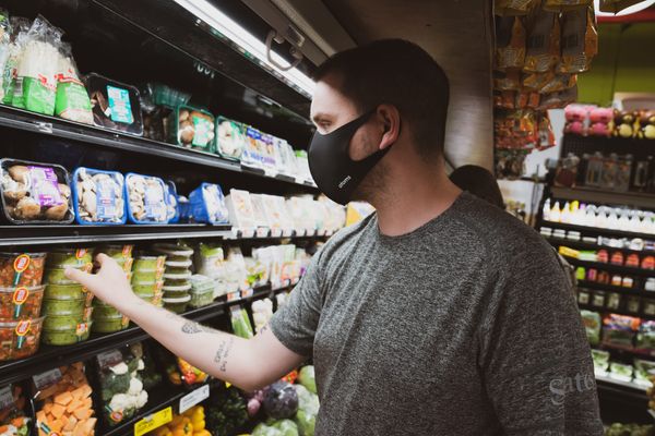 a man wearing a mask at a grocery store